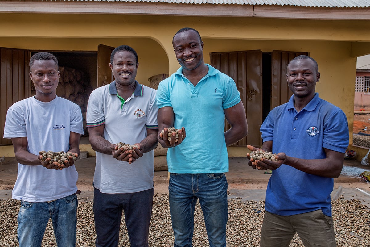 Red River Foods cashew farmers holding drying cashews