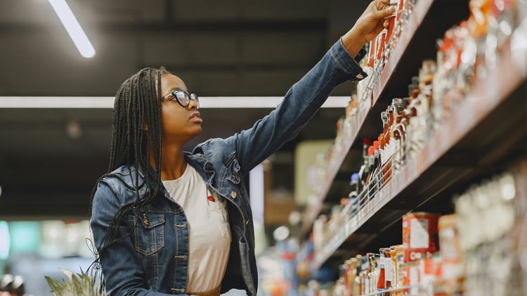 Woman reaching for an item in the grocery store aisle